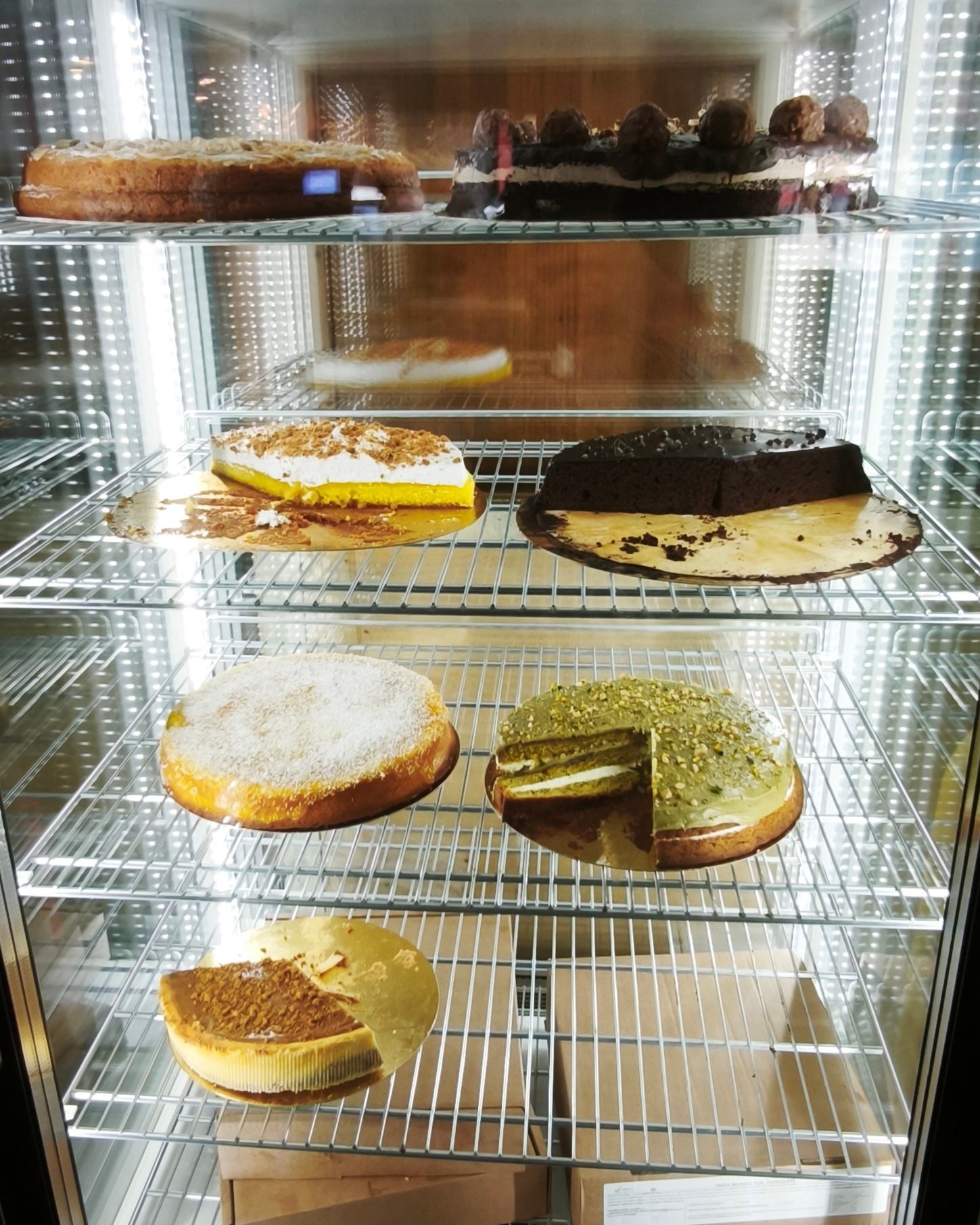 Vitrina refrigerada con varias tartas, enteras y en porciones